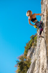 Fototapeta premium The girl climbs the rock.