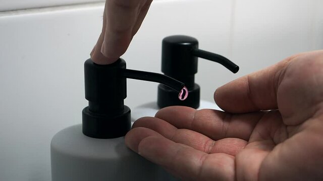 The man takes an antibacterial liquid soap.