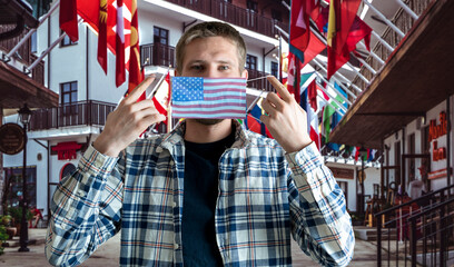 a male person wearing protective face mask with usa flag, pandemic emergency situation