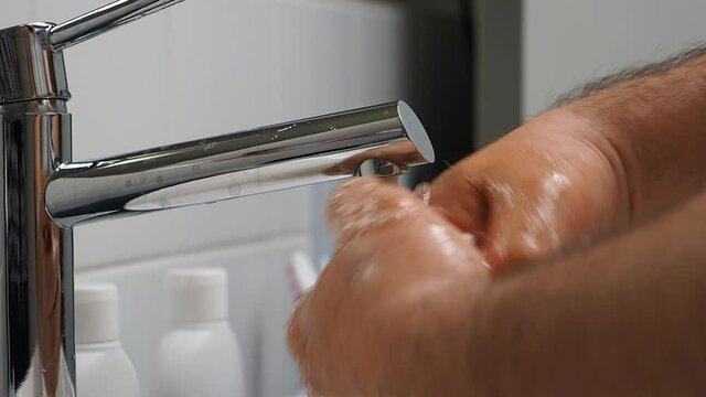 The man washes his hands with soap.