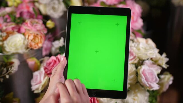 Closeup shots of green screen on iPad. Female person holds in hands portable tablet computer with moving interactive motion tracking points. Touching device surface with fingers, swiping and zooming.