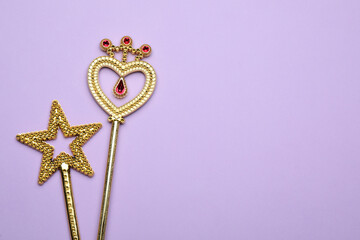Beautiful golden magic wands on lilac background, flat lay. Space for text