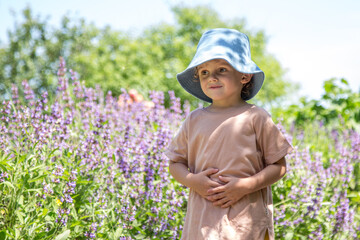 A little boy walks in the park, on a bright sunny day
A walk in the park of a curly-haired boy. Sunny weather, the park is all in multi-colored colors