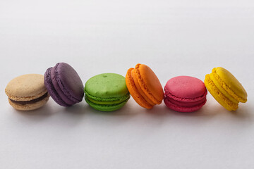 Cake macaron or macaroon on turquoise background from above, colorful almond cookies, pastel colors, vintage card, top view