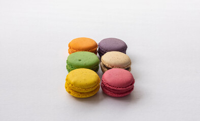 Cake macaron or macaroon on turquoise background from above, colorful almond cookies, pastel colors, vintage card, top view