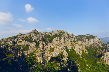Scenic landscape view of limestone mountain with cliff in tropical forest.