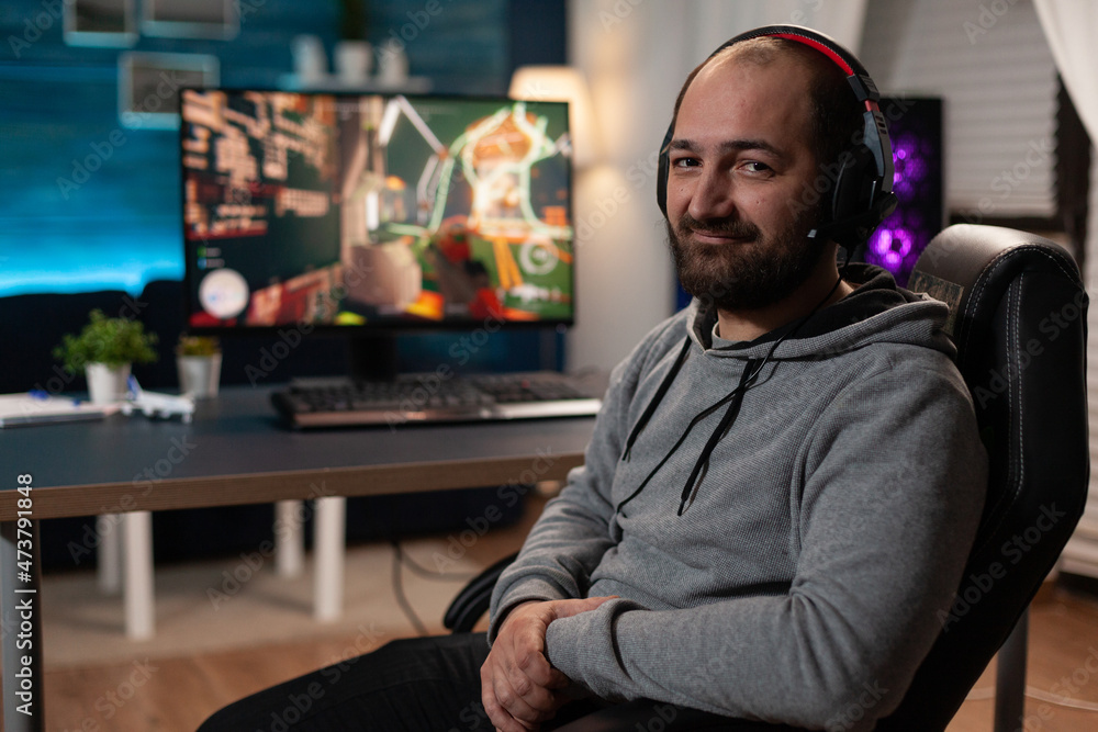 Poster portrait of streamer getting ready to play video games on computer. gamer with headphones preparing 