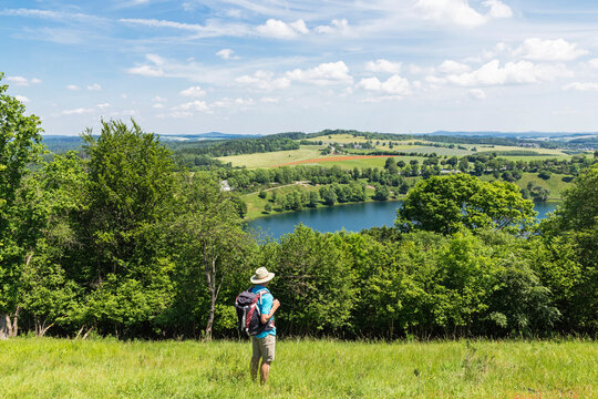 Senior hiker admiring landscape surrounding Weinfelder Maar lake