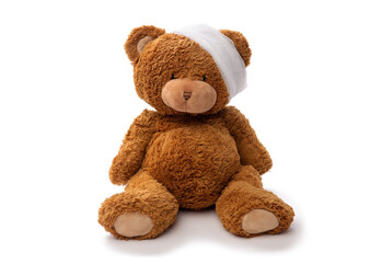 medicine, healthcare and childhood concept - teddy bear toy with bandaged head on white background