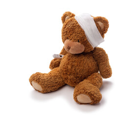 medicine, healthcare and childhood concept - teddy bear toy with bandaged head and thermometer on white background