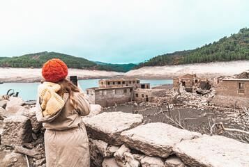 A girl explores the Galician Village Aceredo. In 1992 the village was deliberately flooded and submerged underwater. Every few years when the water levels are low, it' reappears
