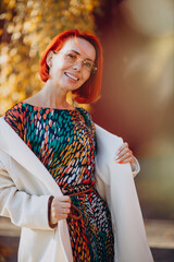 Beautiful elderly woman in colorful dress outside the autumn street