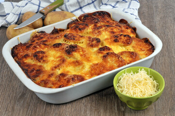 Plat de gratin de pommes de terre avec ses ingrédients et un couteau