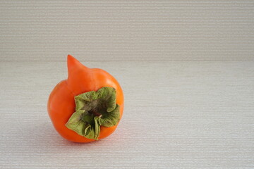Strange forms of persimmon.  Ugly shape fruit in the gray background. Funny, unnormal fruit or food...