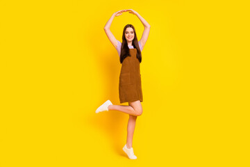 Full length body size view of attractive cheerful carefree girl posing dancing isolated over bright yellow color background © deagreez