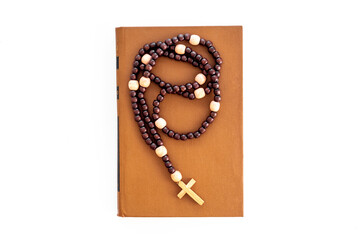 Christian religion concept. Bible book and rosary beads with cross