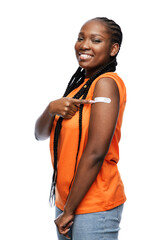 pandemic, vaccination and healthcare concept - happy young vaccinated woman with medical patch on shoulder over white background - obrazy, fototapety, plakaty
