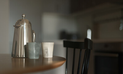 Teapot and two cups on the table in the morning.