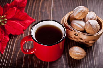 Mug of tea with homemade fresh cookies in a shape of nuts with condensed milk on the wooden table