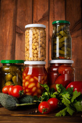 canned vegetables in a glass jar on a wooden background