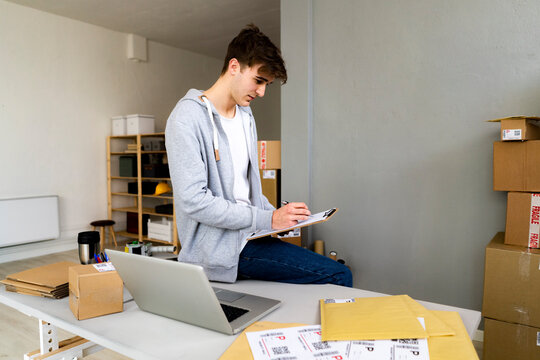 Young male professional working on clipboard at desk