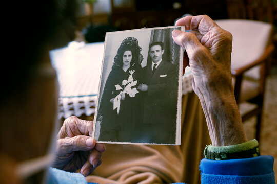 Senior woman looking at old photograph at home