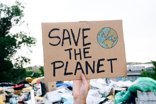 Man holding save the planet text on cardboard