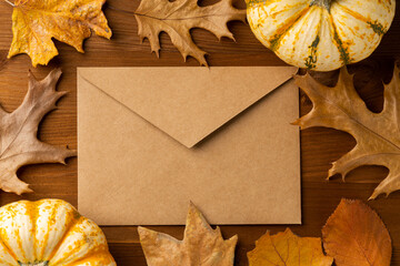 Autumn, fall stationery mockup scene. Blank greeting cards, invitation, craft paper envelope, olive branches, pumpkins on muslin plaid. Dry red beech leafs ground in sunlight. Thanksgiving concept