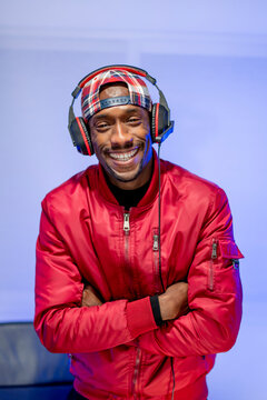 Smiling male influencer with arms crossed standing in studio