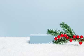 Empty podium in the snow with fir tree and blue background, podium for product, cosmetic and gift presentation