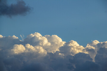 Fototapeta na wymiar Algumas nuvens fofas no céu do final da tarde.