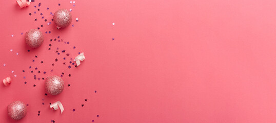 Golden christmas decorations on trendy pink background. Christmas New year or party banner. Copy space