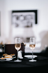 two glasses on a black table with snacks, a date