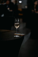 a glass of champagne and a telephone on a black table