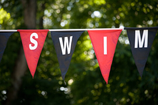 swim banner pennant signage hanging outdoors, close-up and full frame