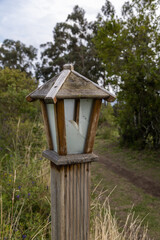 beautiful lamp with wooden house design next to a dirt road in a forest, nature in the day