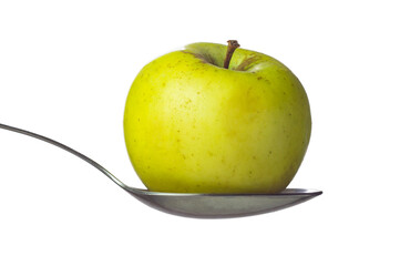 Whole green apple in spoon isolated