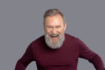 Obraz premium Mature man in burgundy shirt looking excited