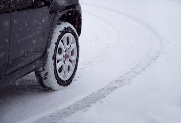 Winter Tires, winter car equipment, Snow tires on a snowy and snow-covered road surface, road safety during a heavy snowfall concept with copy space