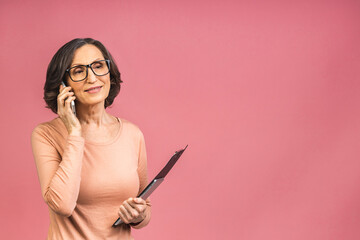 Photo portrait of senior mature aged business woman concentrated keeping clipboard and mobile phone...