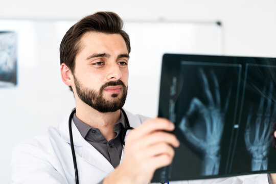 Handsome male healthcare worker examining x-ray