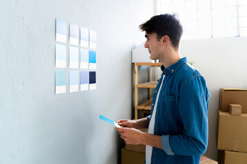 Male professional looking at blue cards on wall in warehouse