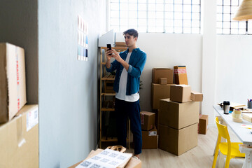 Male professional photographing blue cards in office