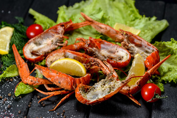 boiled crayfish cut in half on lettuce with tomatoes

