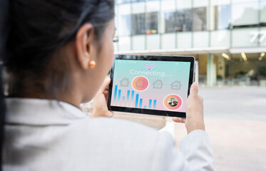 Businesswoman connecting home surveillance with wifi connection on digital tablet