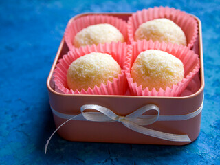 A gift made with love: four exquisite white chocolate and coconut truffles in a beautiful peach candy box with a bow.