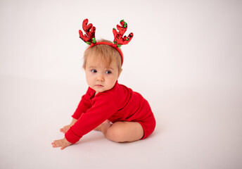 little girl in a red suit with a New Year's gift. Child and New Year. A beautiful red bow on the girl's head. A beautiful child is smiling. baby on a white background.box with a gift for the new year
