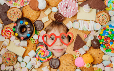 Little girl lying under plenty of sweet foods