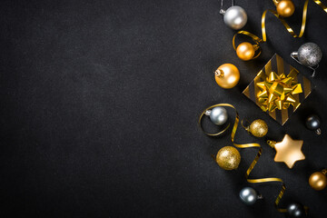 Black christmas background with golden decorations. Flat lay image with space for design.