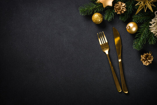 Christmas Table With Golden Cutlery And Christmas Decorations At Black Background. CHristmas Food Concept. Top View With Copy Space.